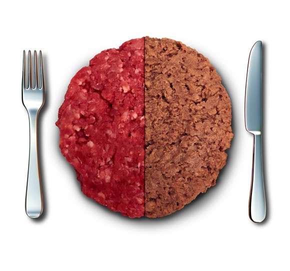 Vegan burger concept showing a contrast between faux and real meat, or two iterative versions of a plant-based formula, flanked by a knife and fork..