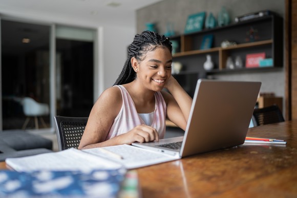 Person smiling while looking at computer. 