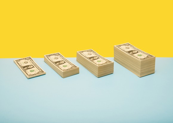 Four stacks of dollar bills increasing in size