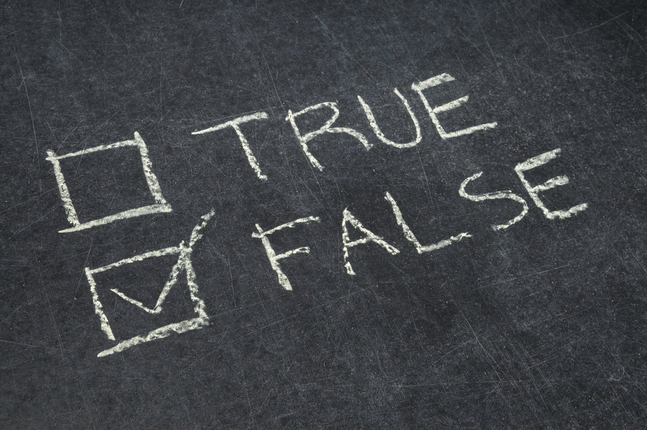 "True" and "false" written on a chalkboard, with false checkbox checked off.