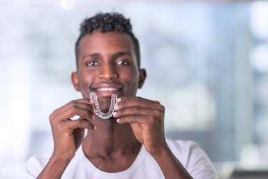 Male holding up an invisaligner