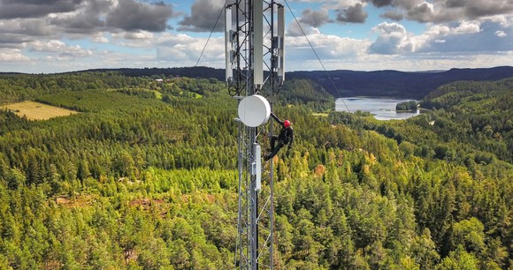 Tower climber on a tower working on telecom equipment.