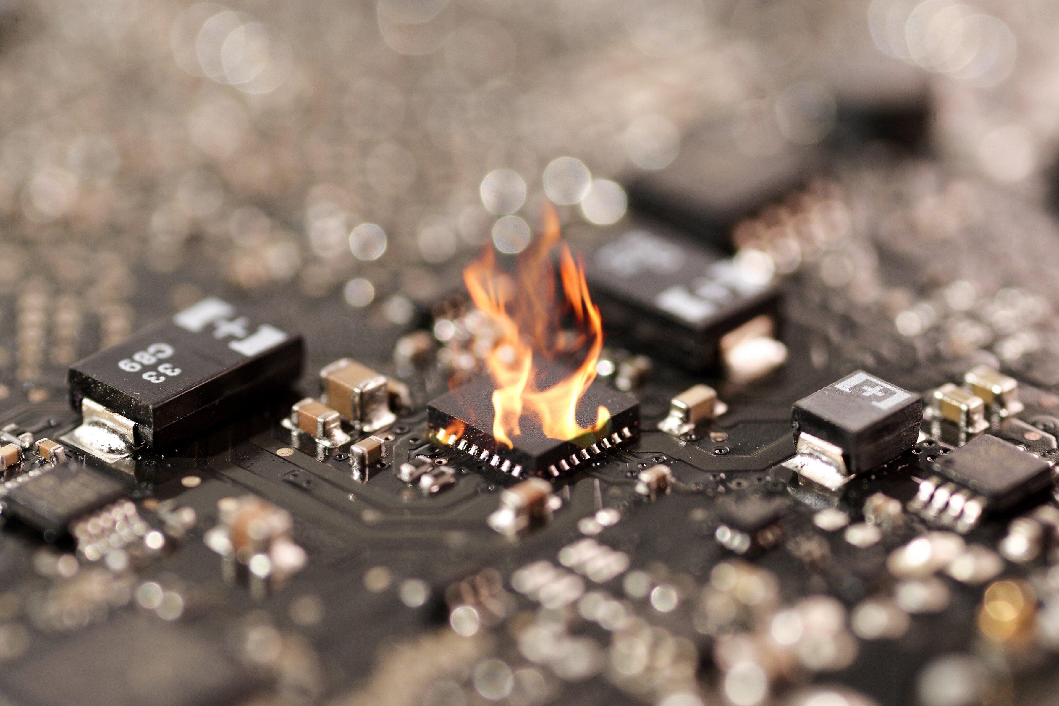 Photo of a circuit board where a single chip is on fire.