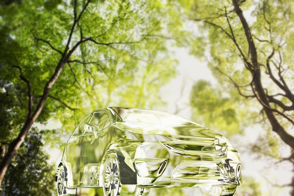 Transparent car among green trees