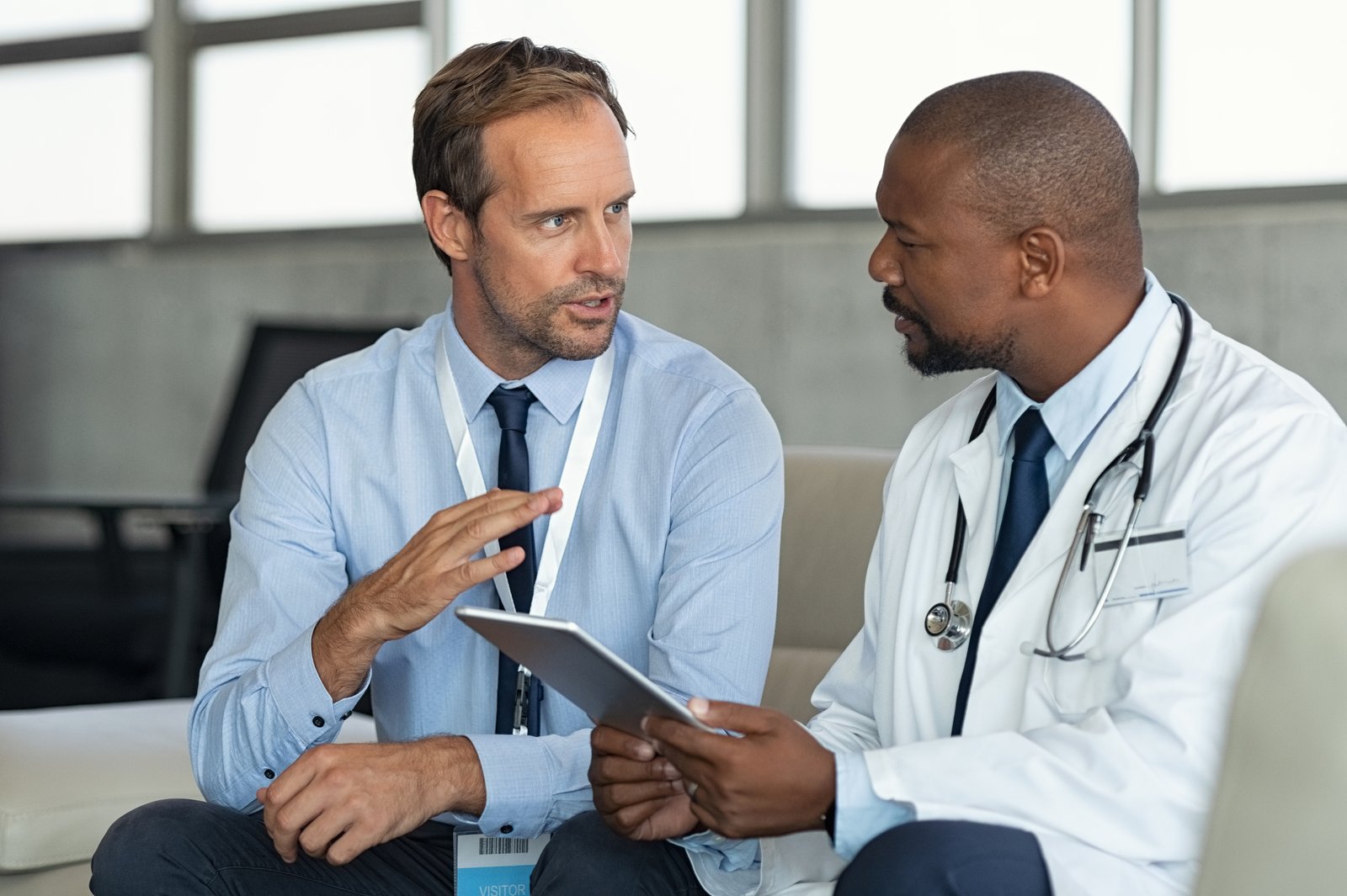 Sales professional discussing information on a tablet with a physician