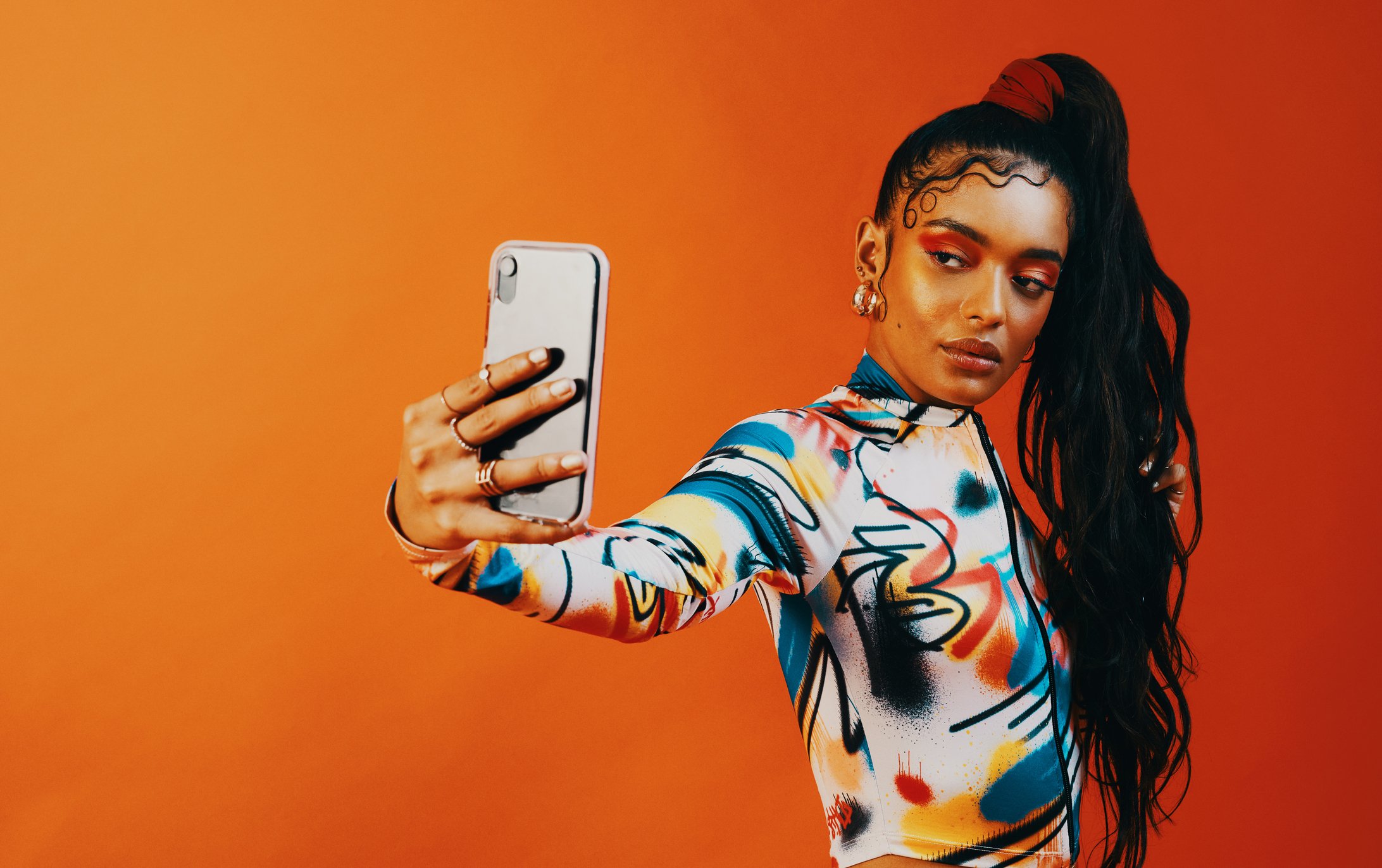 A fashionable young woman takes a selfie.