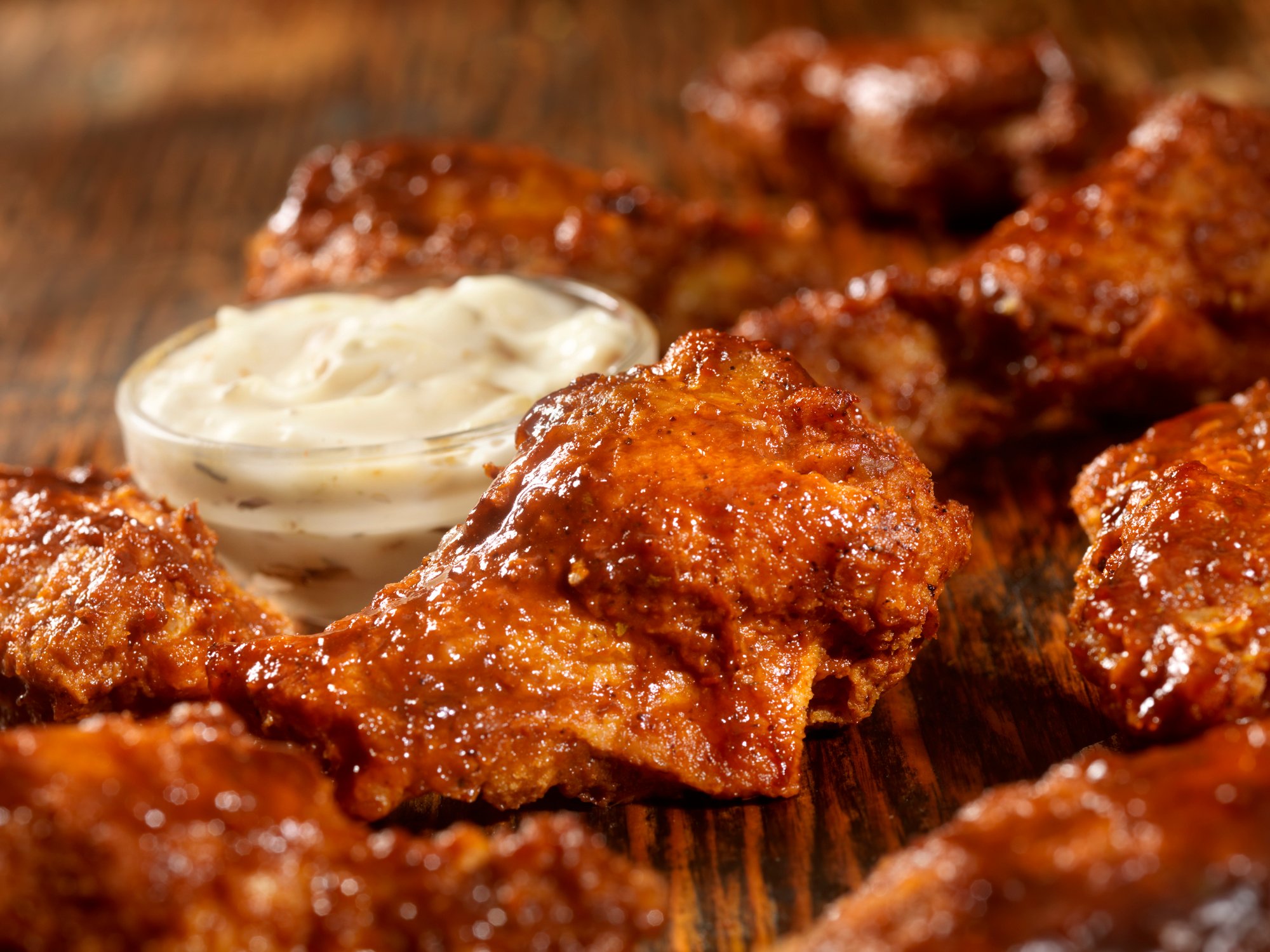 Fried chicken drumlets accompanied by a saucer filled with mayonnaise.