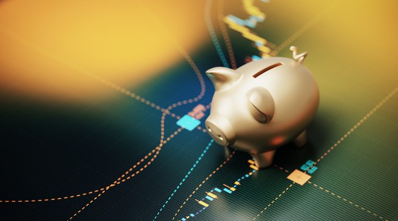 A small piggy bank placed on a stock trading screen.