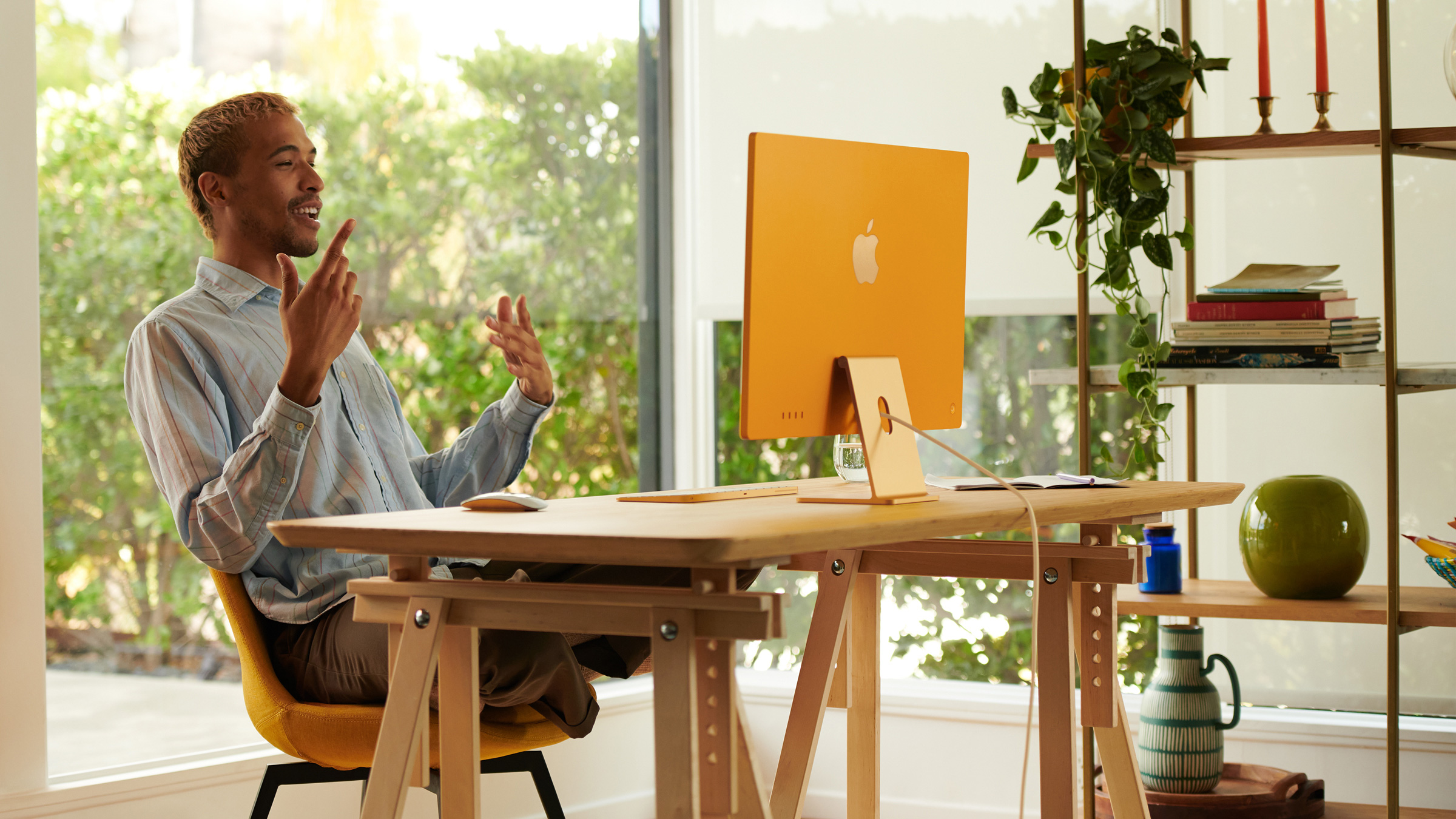 Man sitting in front of a new orange iMac.