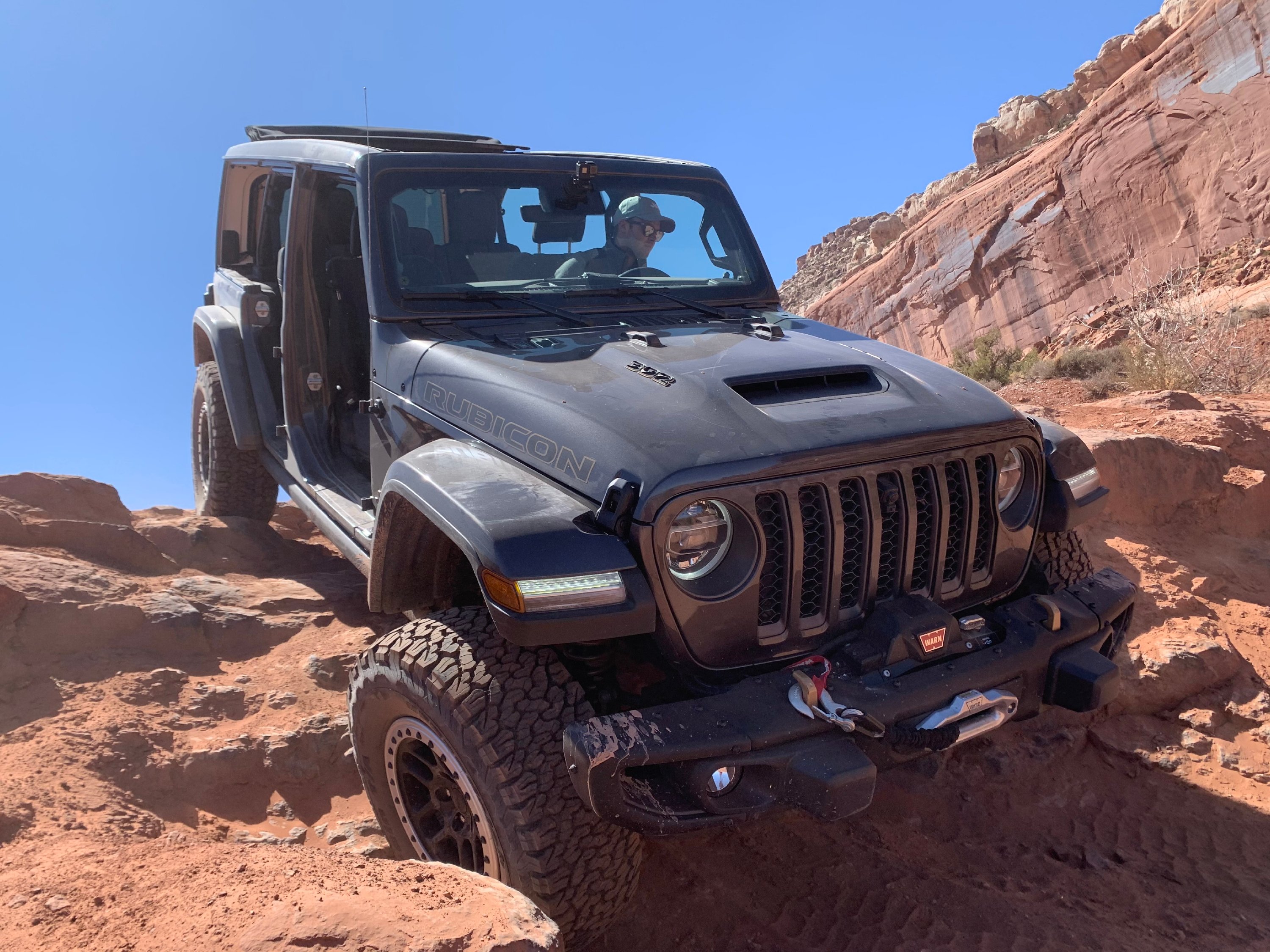 A 2021 Jeep Wrangler Rubicon 392, an off-road SUV, descending a rocky hill.