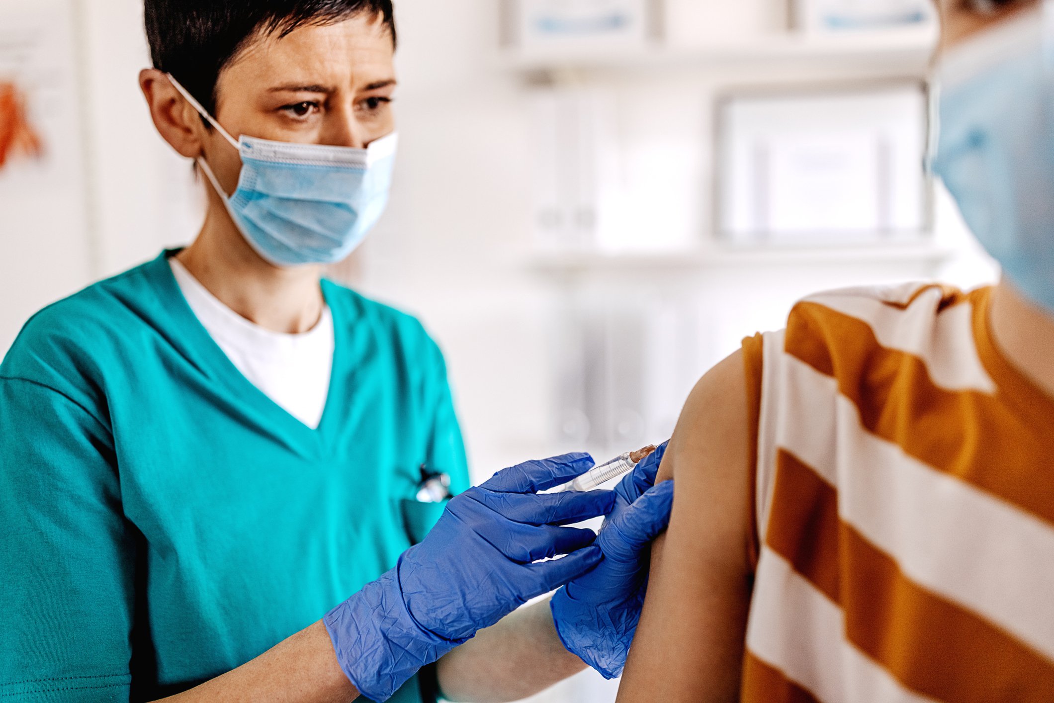 Healthcare professional giving a vaccine shot to a young boy