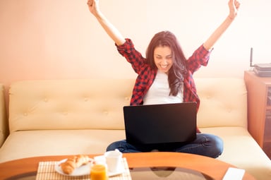 Young woman celebrating with computer