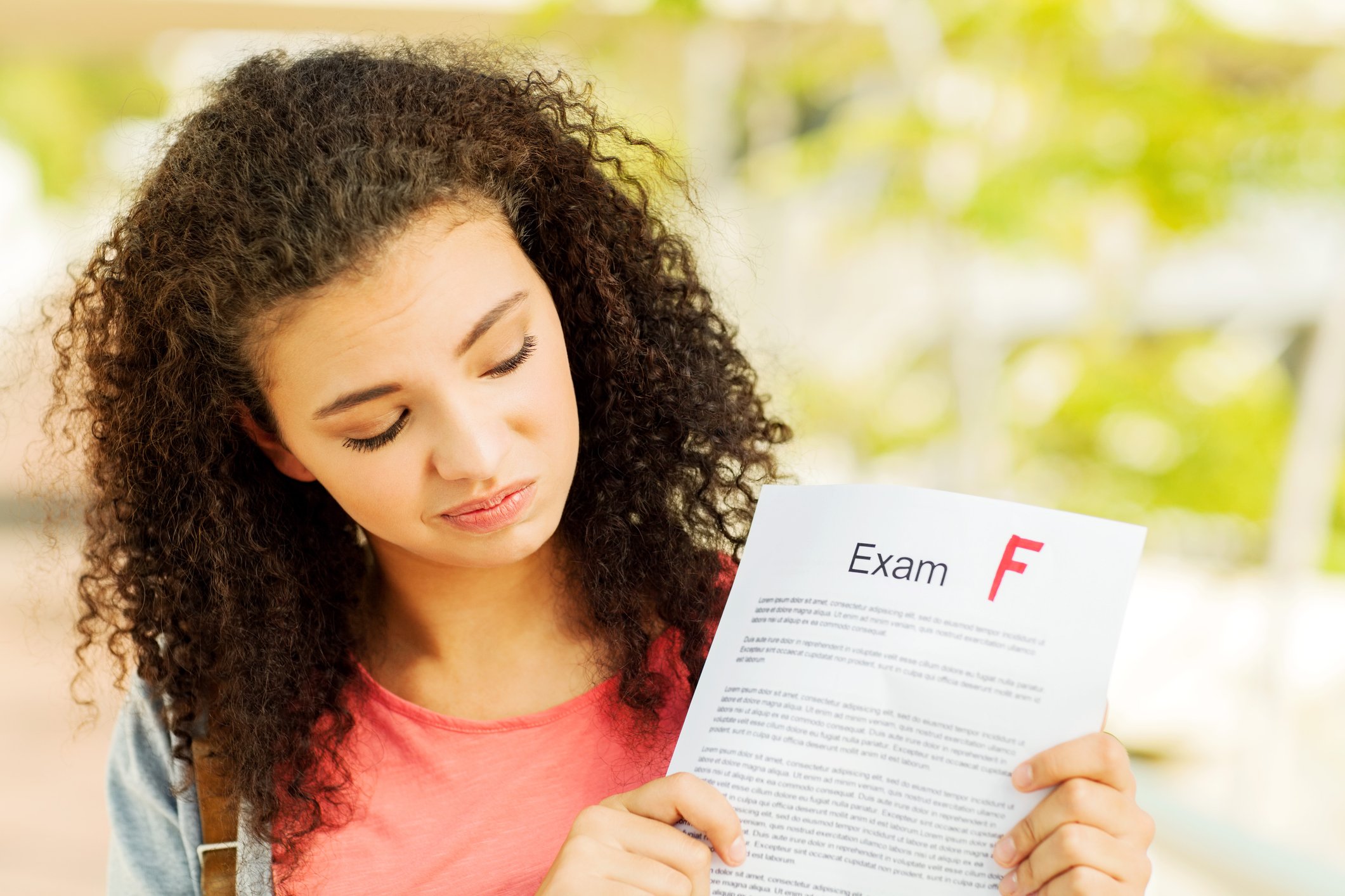 Unhappy student looks at an exam graded F
