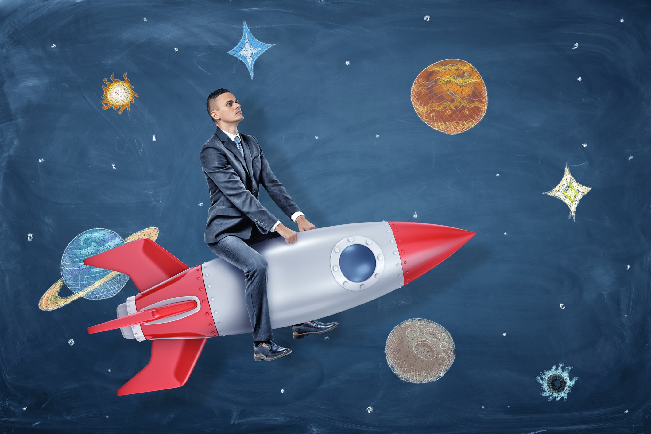 A business man sits on a rocket in front of a background drawing of stars and planets.