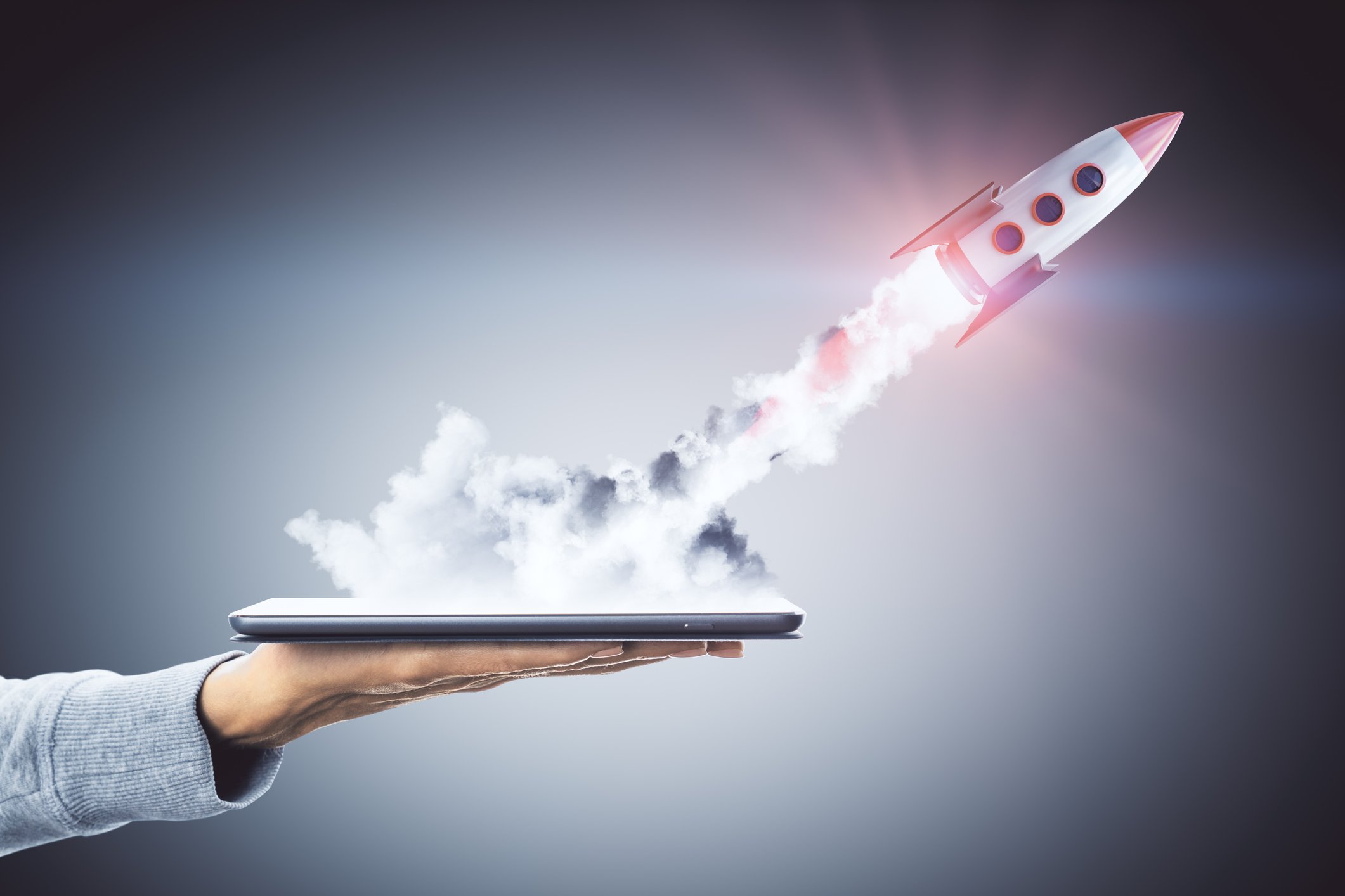 A rocket takes off from a tablet computer's screen.