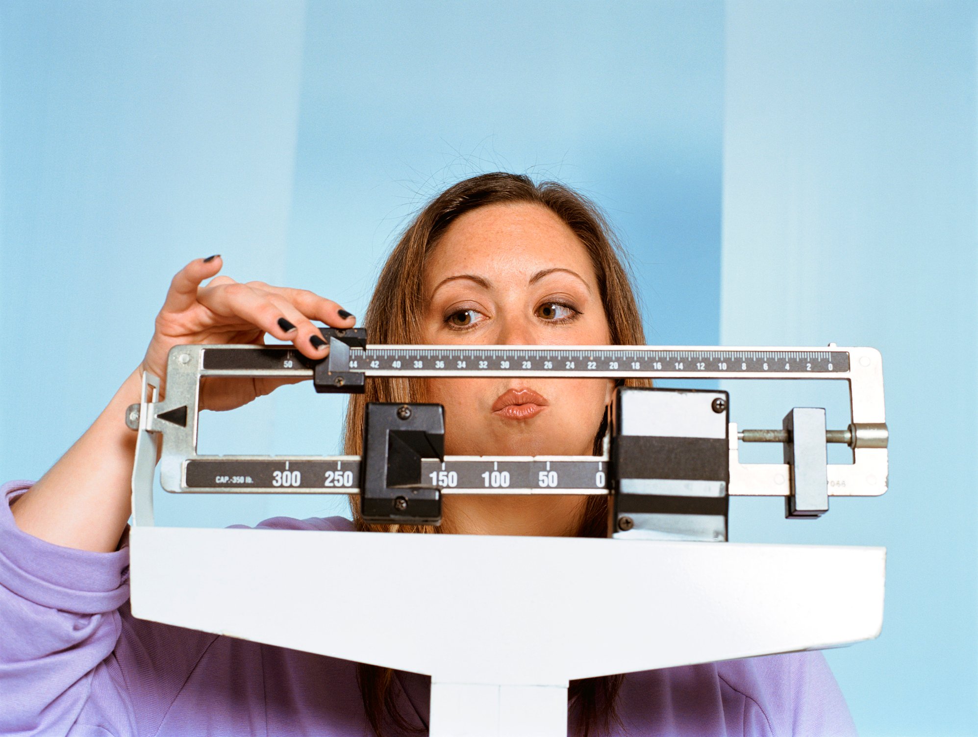 Woman checking her weight on a scale