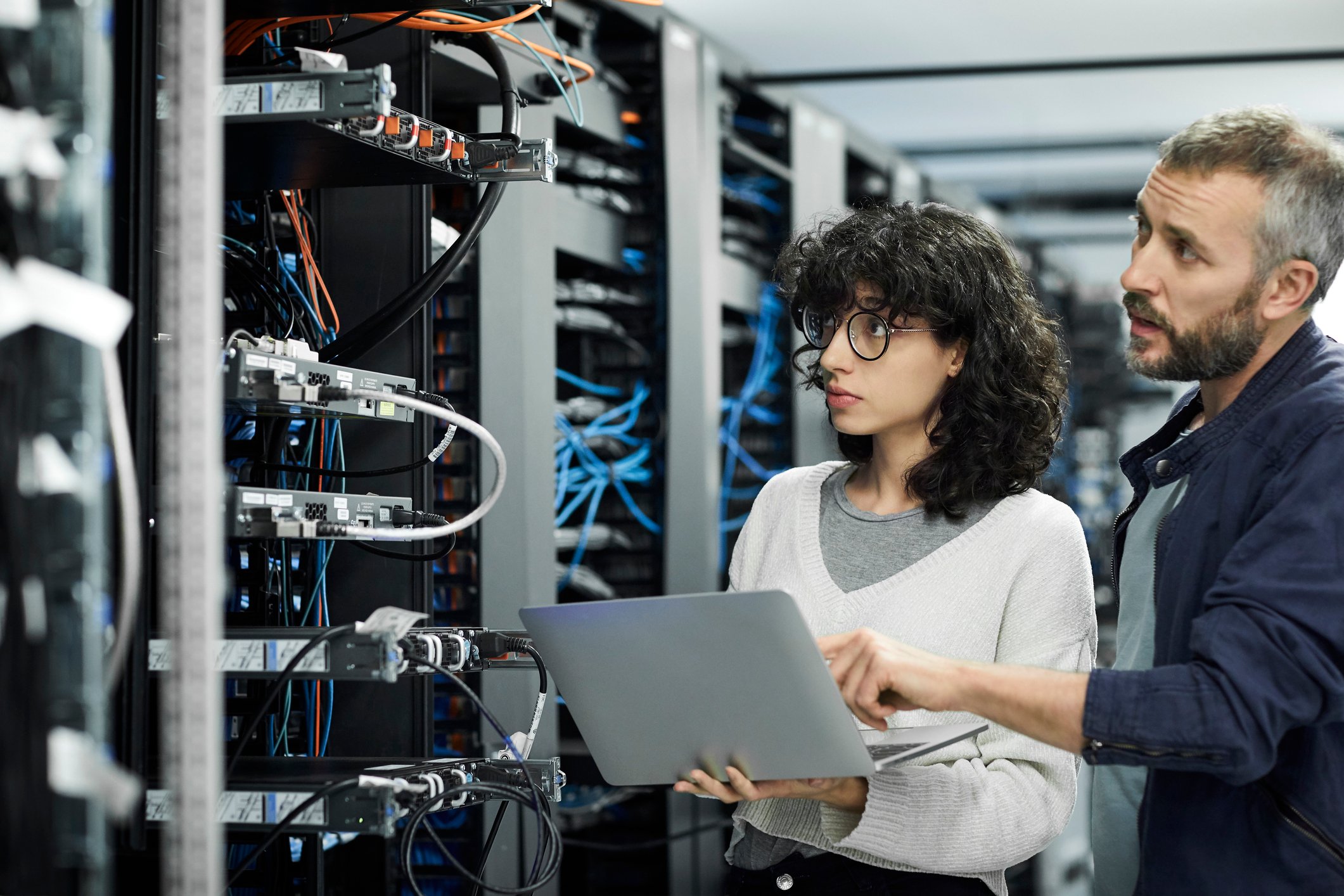 Two technicians inspecting a server room.