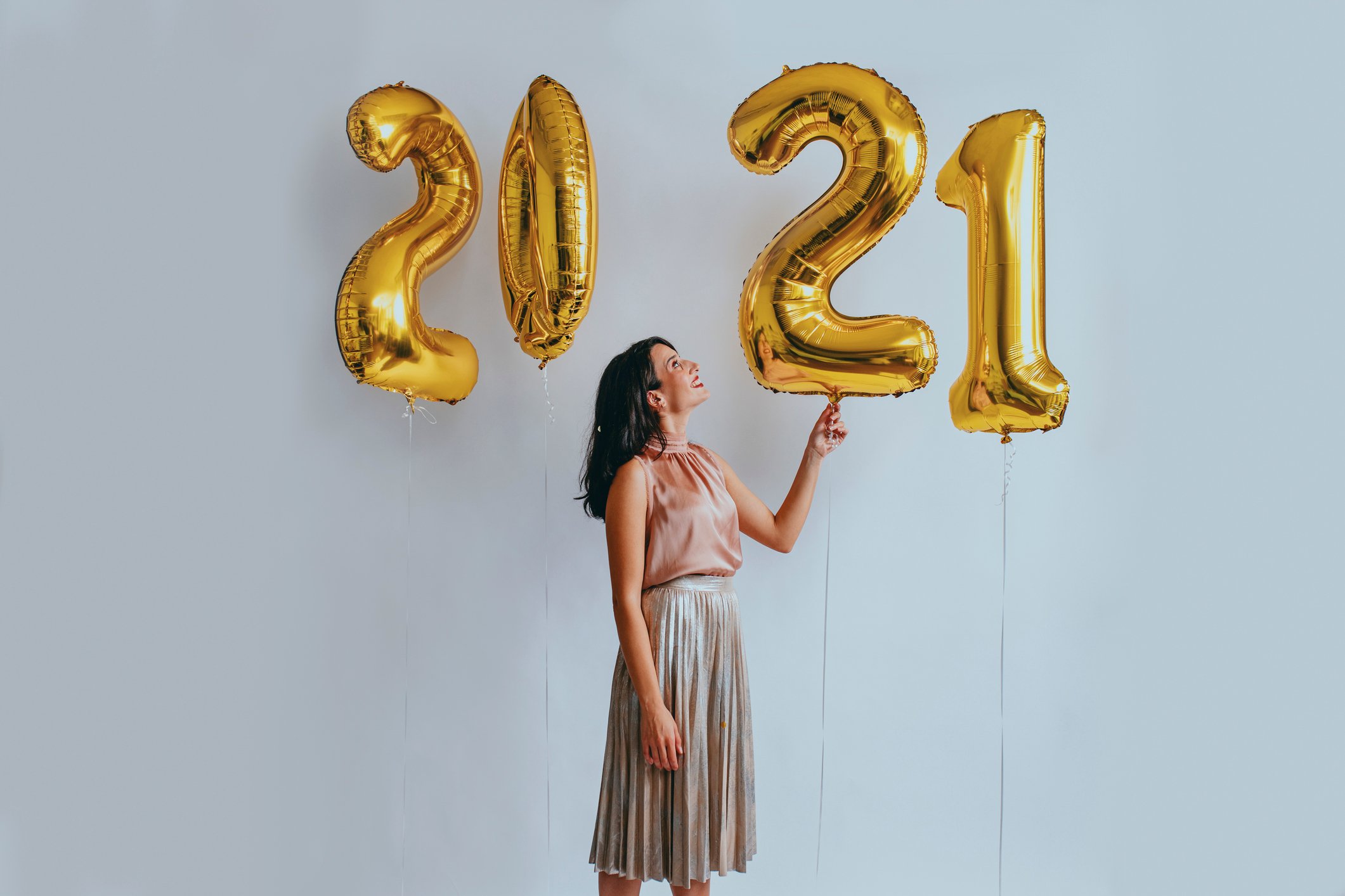 A woman looks at number balloons spelling out 2021