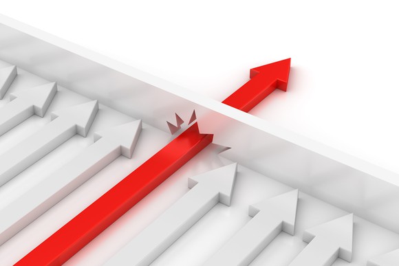 A red arrow crashes through a barrier inhibiting multiple gray arrows.