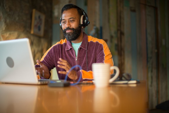 A man with headphones sitting in front of a computer.