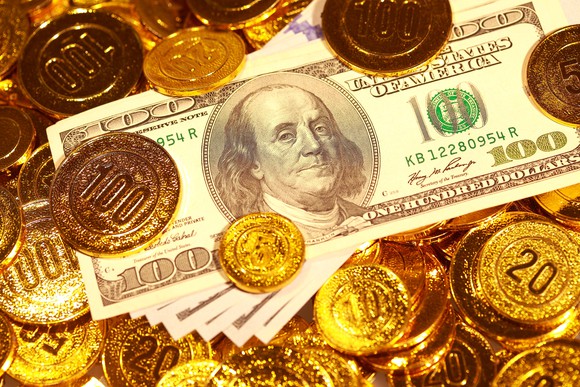 Gold coins strewn around dollar notes.