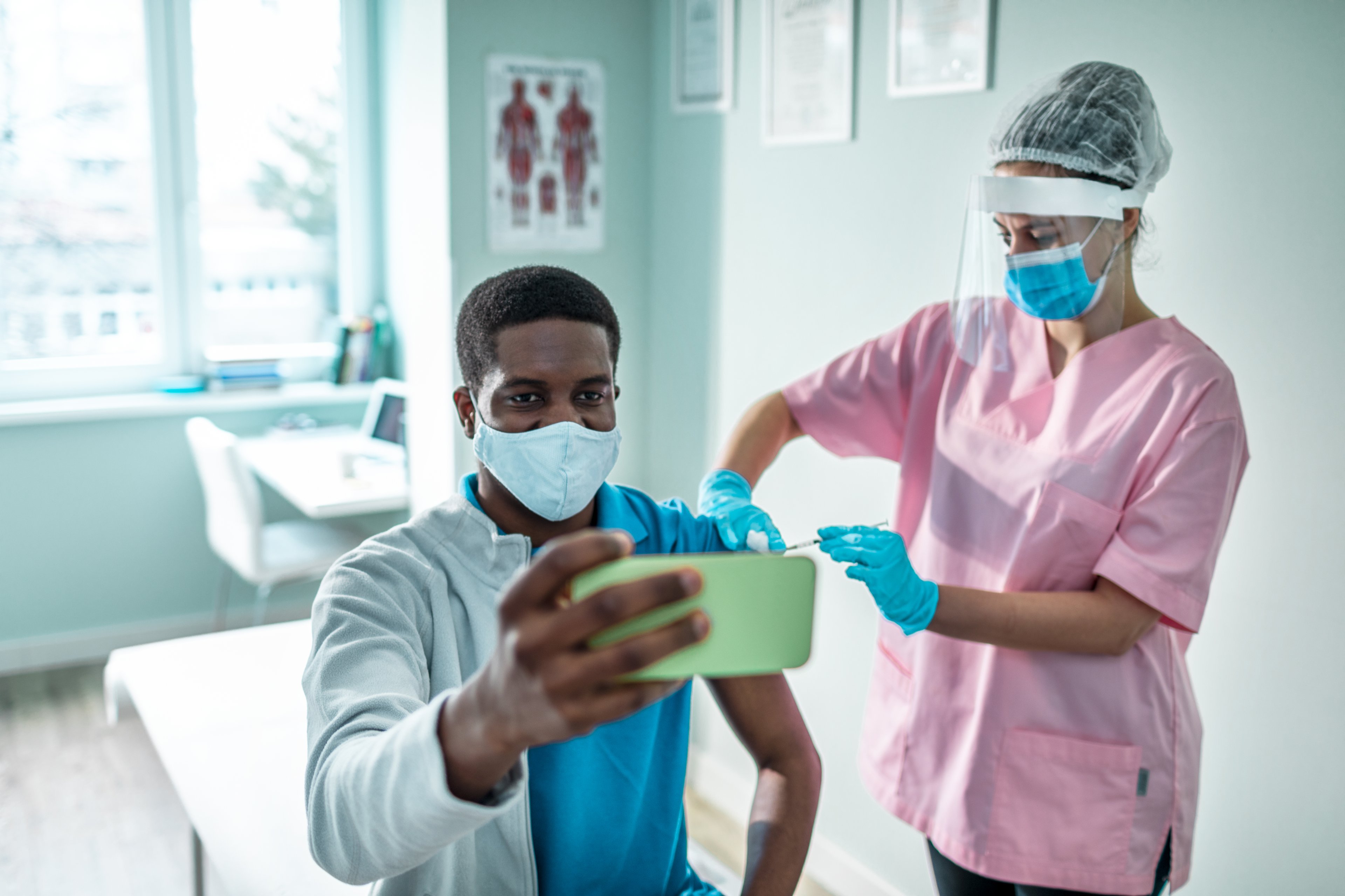 Man taking a selfie while receiving a coronavirus vaccine. 