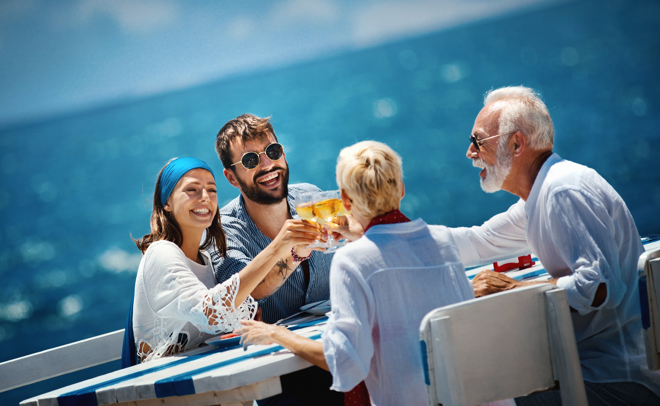 A group of four toasts with champagne on a cruise deck. 