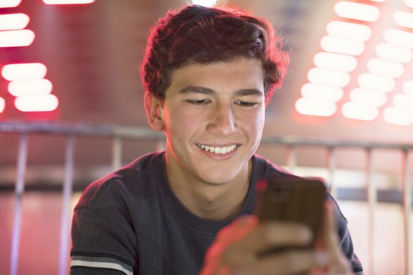 smiling young person looking at phone