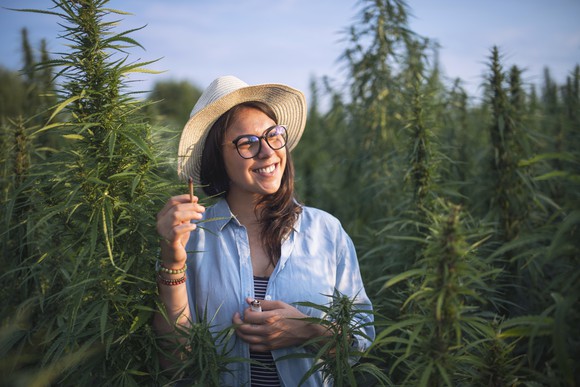 Woman smoking cannabis in a hemp field. 