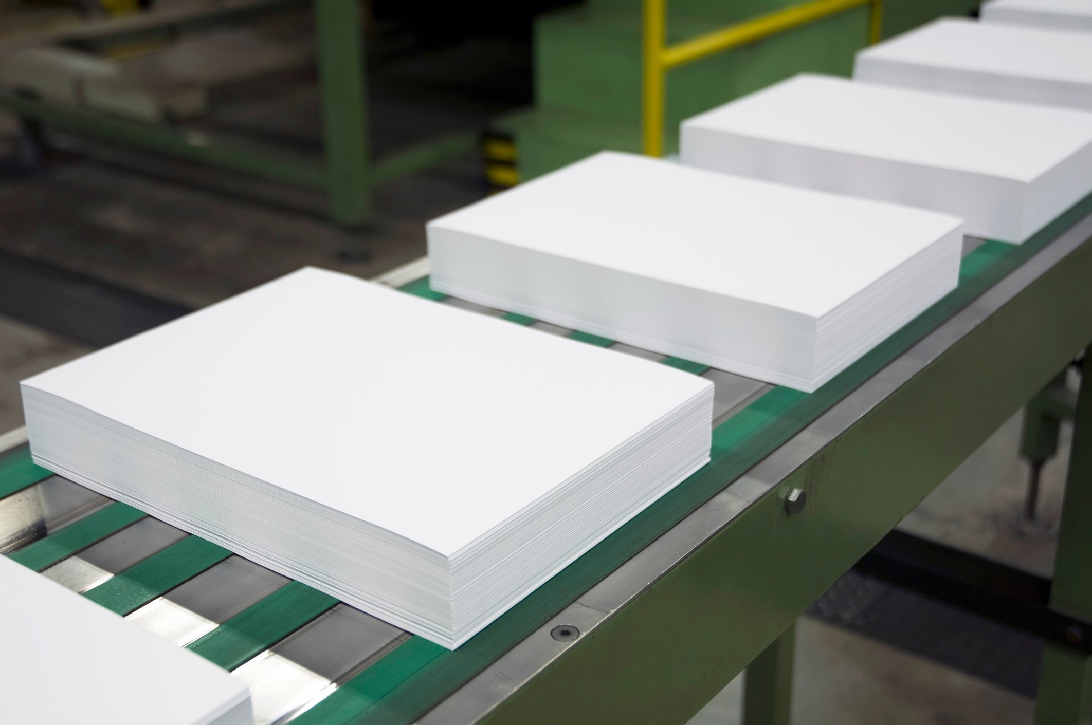 Stacks of paper on a conveyer belt.