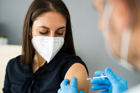A nurse vaccinates a woman with a coronavirus vaccine.