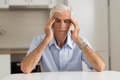 Older man holding his head_GettyImages-1003643746