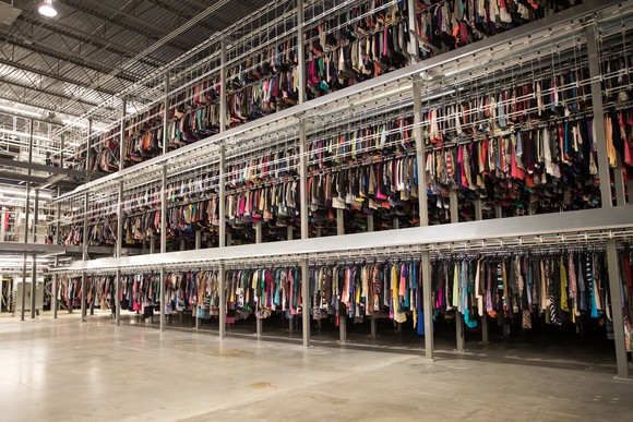 A ThredUP distribution center shows an extensive selection of clothes hanging up.