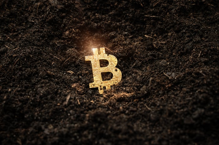 Bitcoin symbol in the dirt. 