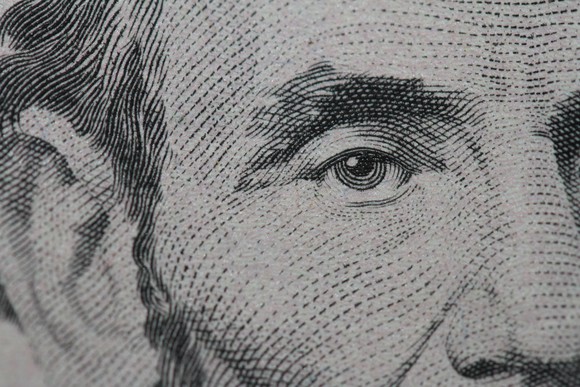 A close up of Abraham Lincoln's face on the $5 bill. 