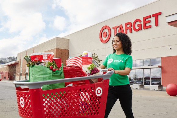 A Target Shipt worker with an order in a Target parking lot.