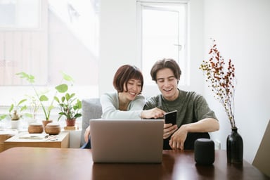 Smiling young couple with laptop and smartphone