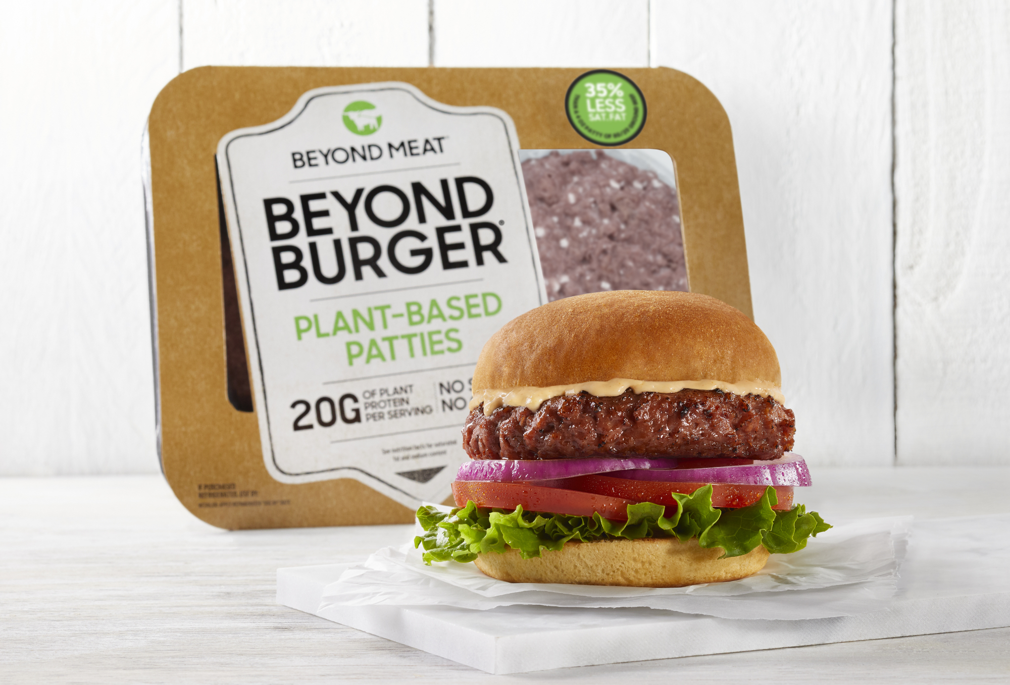 a product shot shows a Beyond Meat burger sitting on a plate in front of a Beyond Burger package