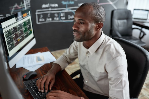 A person sitting down in front of computer screens 