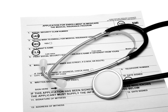 Stethoscope over Medicare enrollment form.