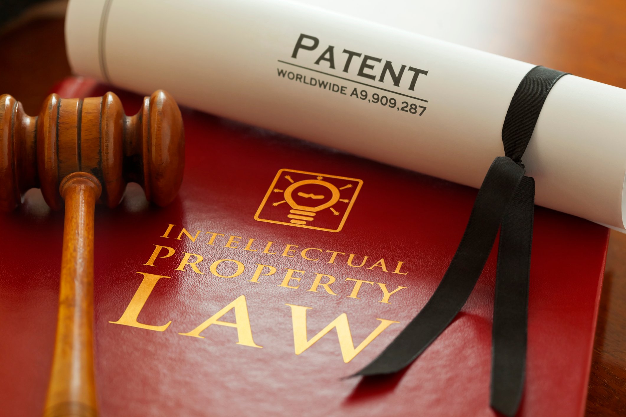Gavel on book of intellectual property law with patent scroll