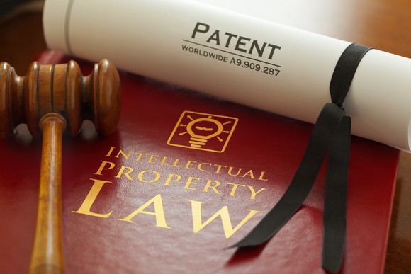Gavel on book of intellectual property law with patent scroll