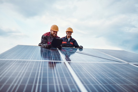 Two men working on solar panels.