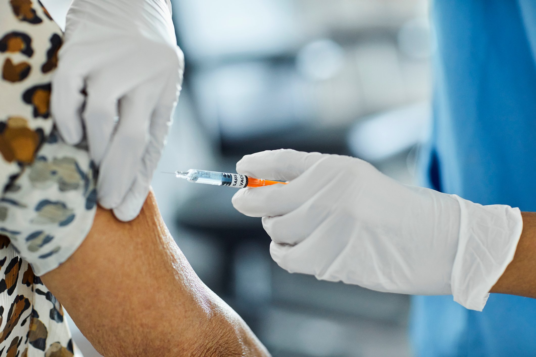 A healthcare worker administers a vaccine.
