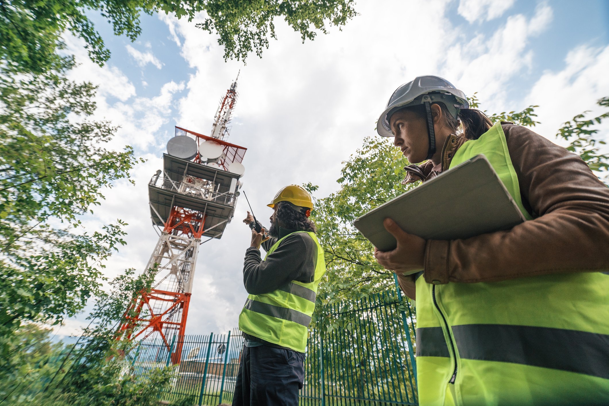 Two telecom workers surveying a communications tower.