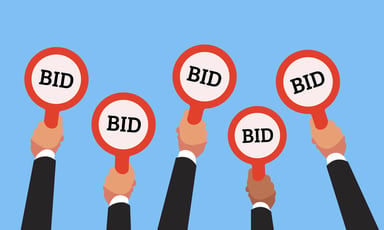 Cartoon hands hold up bid paddles at an auction
