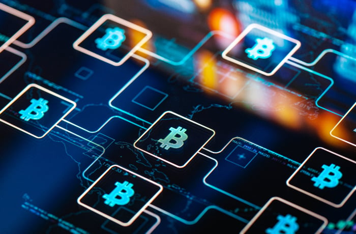 Diagram of an interwoven chain of blocks marked with the Bitcoin symbol.