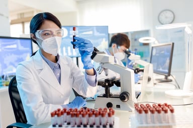 Scientisting holding vial with blood sample