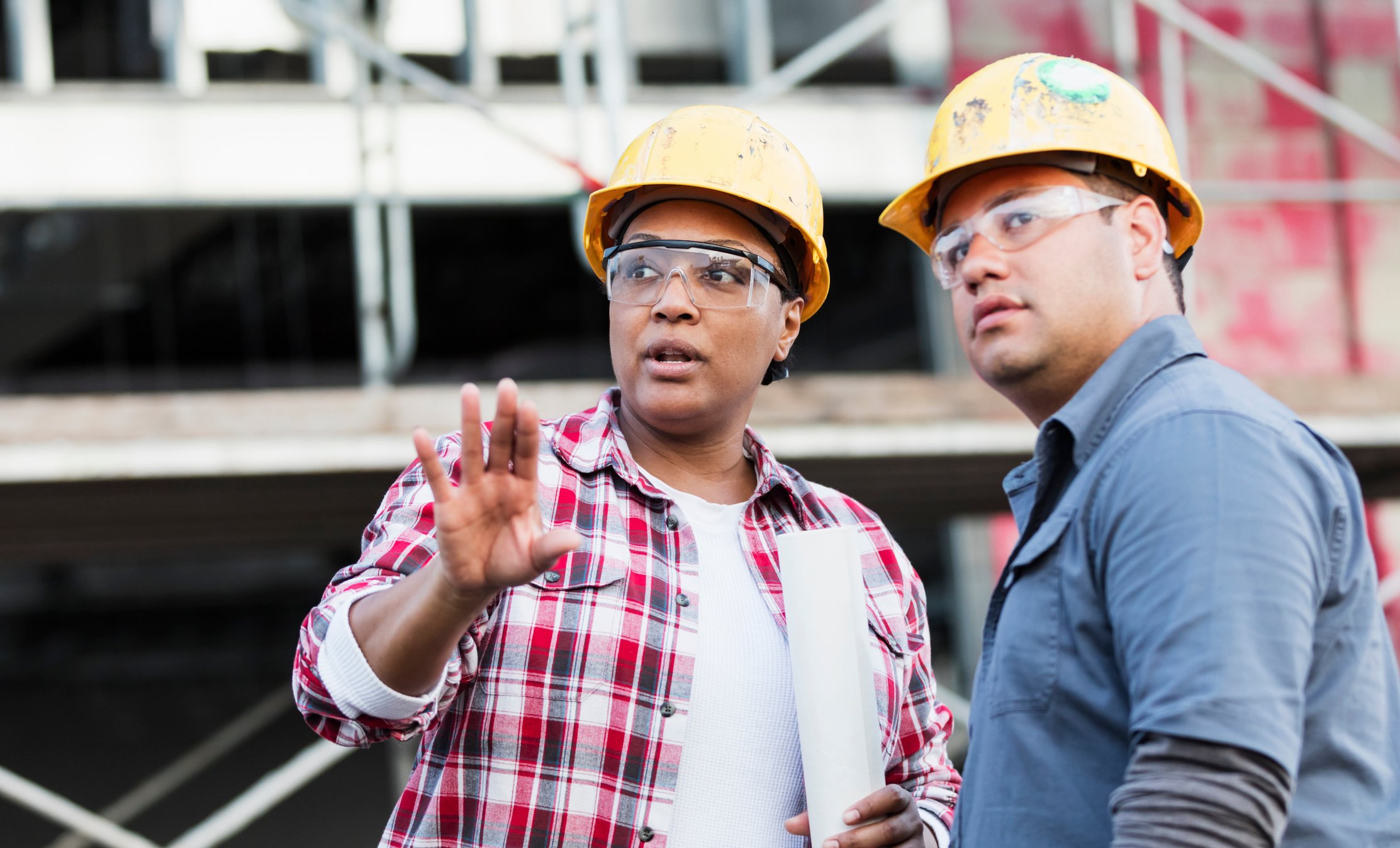 Two construction workers talking on a project site.