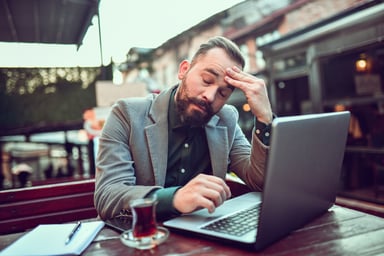 stressed investor drinking tea with laptop